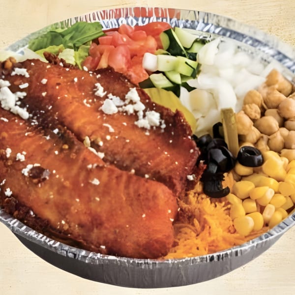 Mediterranean bowl with crispy chicken, feta, lettuce, tomatoes, cucumbers, onions, chickpeas, corn, and olives.