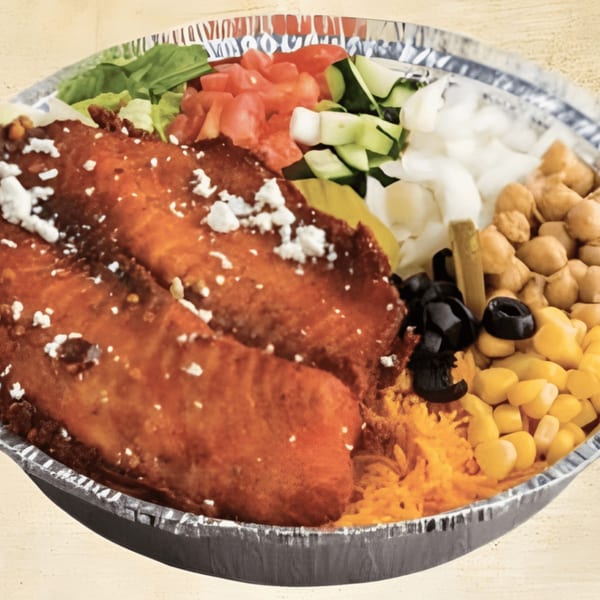 Mediterranean bowl with chicken, feta, lettuce, tomatoes, cucumbers, onions, chickpeas, olives, and corn.